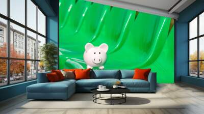 Piggy bank on the green seats of sports ground Wall mural