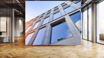 Abstract closeup of the glass-clad facade of a modern building covered in reflective plate glass. Architecture abstract background. Glass wall and facade detail. Wall mural