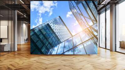 Facade texture of a glass mirrored office building. Fragment of the facade. Bottom view of modern skyscrapers in business district in evening light at sunset with lens flare filter effect. Wall mural