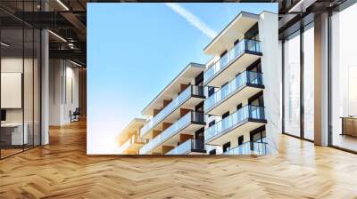 Modern apartment buildings on a sunny day with a blue sky. Facade of a modern apartment building. Glass surface with sunlight. Wall mural