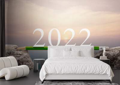 2022 white text with green pencil on rock mountain over aerial view of cityscape at sunset, vintage style, Business success strategy planning concept, Happy new year 2022 calendar cover Wall mural