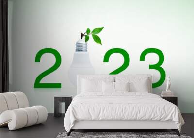 2023 text and LED light bulb with fresh green tree leaves, Happy new year 2023 ecology and saving energy concept Wall mural