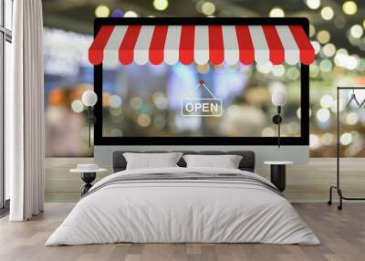 Desktop modern computer monitor with online shopping store graphic and open sign on wooden table over blur light and shadow of shopping mall, Business internet shop online concept Wall mural