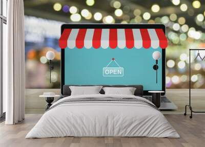 Modern laptop computer with online shopping store graphic and open sign on wooden table over blur light and shadow of shopping mall, Business internet shop online concept Wall mural