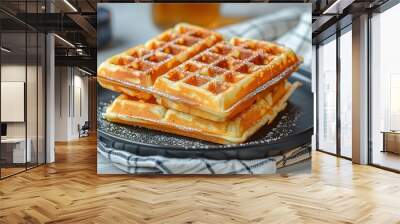 A black plate with two waffles on it, sitting next to the same white and navy checkered kitchen towel. Wall mural