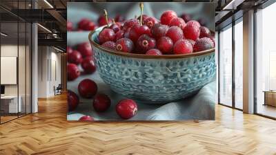 A bowl of red berries sits on a table Wall mural