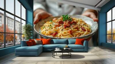 Closeup of hands holding an elegant white plate with a pasta dish Wall mural