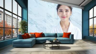 Beautiful Young Asian Woman Smiling in White Bathrobe Against Marble Bathroom Background - Spa Day Wall mural