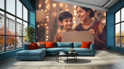 Indian mother and son in modern casual attire, holding big silver parallelogram-shaped board, festival celebration Wall mural