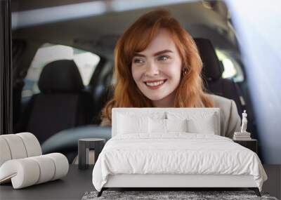 Beautiful young woman driving her new car at sunset. Woman in car. Close up portrait of pleasant looking female with glad positive expression, woman in casual wear driving a car Wall mural