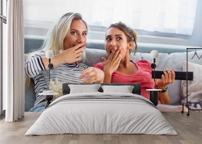 Portrait of a happy girlfriends eating popcorn and watching tv at home. Girls night, entertainment and junk food concept watching tv and movies Wall mural