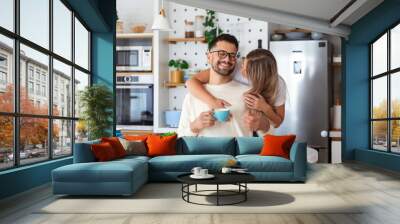 Romantic couple in love spending time together in kitchen. Cute young couple drinking coffee in kitchen and enjoying morning time together Wall mural