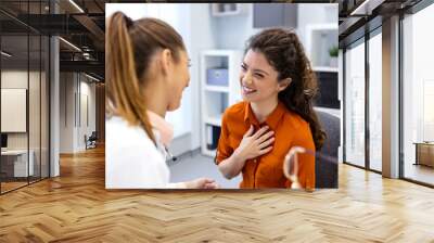 Young female professional doctor physician consulting patient, talking to adult woman client at medical checkup visit. diseases treatment. medical health care concept Wall mural