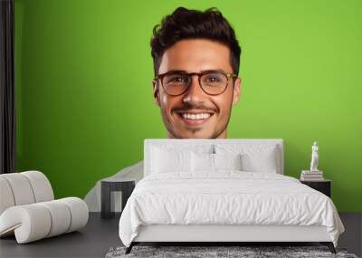 A confident millennial man in glasses, his bright smile and approachable expression captured in a headshot portrait against a solid lime green background Wall mural