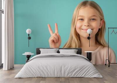 Smiling girl with peace gesture on blue background Wall mural