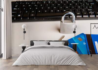 Concept of expense control, a closed padlock and a key next to credit cards, in the background a computer keyboard, on a white background.
 Wall mural