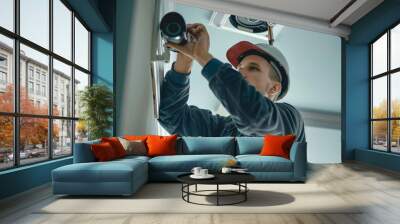 Professional Camera Installation, Technician in hard hat installing a security camera on the ceiling. Wall mural