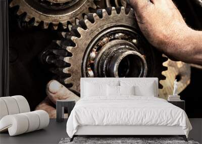 Man repairs engine of tractor, agricultural machinery. Bearing, gears, close-up. Wall mural