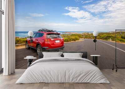 Red car parked in scenic spot along ocean drive in South Australia Wall mural