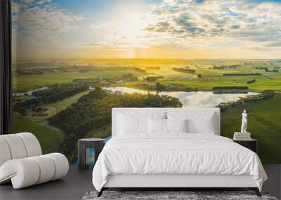 Sun setting over scenic Australian countryside grasslands and pastures with river passing through - aerial panorama Wall mural