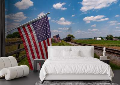 View of American Flags Waving on a Fence After a Steam Passenger Train Passed on a Sunny Summer Day Wall mural