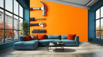 Hammer, pliers, screwdriver on an orange background, top view, a place for an inscription Wall mural