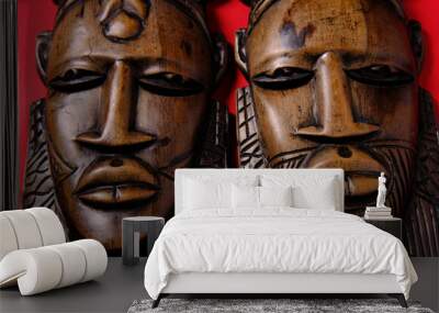 Vintage wooden African masks on red background, top view Wall mural