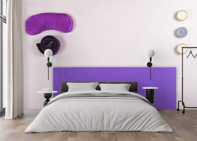 Composition of yoga, meditation or pilates accessories on white background with copyspace. Top view of violet yoga mat, violet belt, silky eye pillow and candles on pink background with copyspace. Yo Wall mural