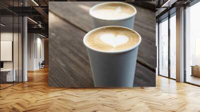 Two white paper cups of coffee on wooden table. Wall mural