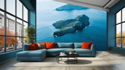 Aerial view of a group of small, scattered islands in a vast ocean, focusing on the contrast between the land and water. Emphasize the isolation and simplicity of the scene.  Wall mural