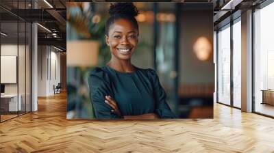 Portrait of smiling young black businesswoman standing in modern office and looking at camera. Wall mural