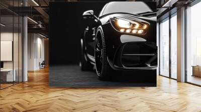 Black luxury car with glowing headlights isolated on a black background. Wall mural