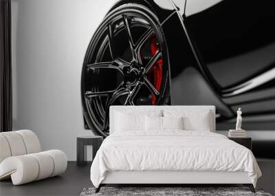 Close-up of a black sports car wheel on a white background. Wall mural