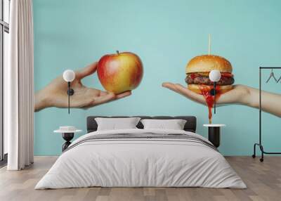 Two hands holding an apple and a burger on blue background.. Wall mural