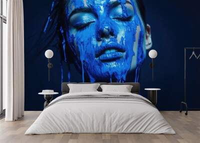 Woman covered in blue paint against a solid dark background. Wall mural