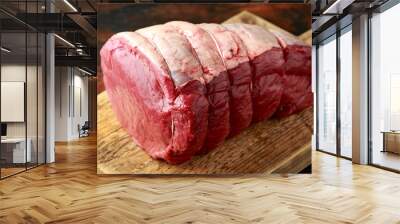 butcher slicing Fresh Raw top side beef meat on rustic wooden chopping board Wall mural