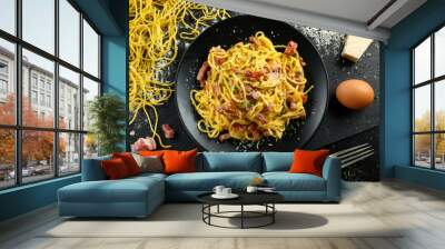 Classic Homemade Pasta carbonara Italian with Bacon, eggs, Parmesan Cheese on black plate. Wall mural