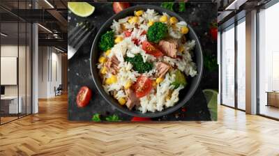 Fresh Tuna rice salad with sweet corn, cherry tomatoes, broccoli, parsley and lime in black bowl Wall mural