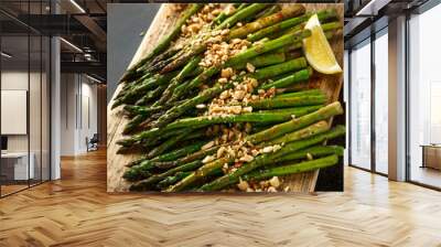 Fried asparagus tips served with crispy crushed peanuts on wooden board Wall mural