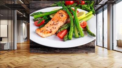 Fried salmon with asparagus, tomatoes, lemon, yellow lime on white plate Wall mural