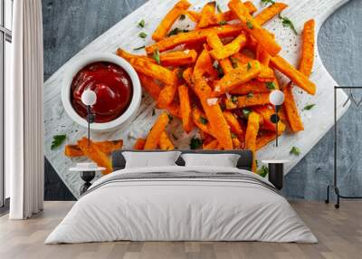 Healthy Homemade Baked Orange Sweet Potato Fries with ketchup, salt, pepper on white wooden board Wall mural