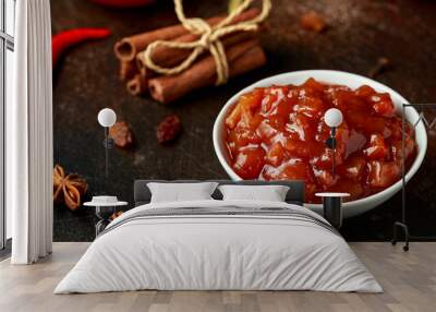 Homemade apple and chilli chutney with spices on dark background Wall mural