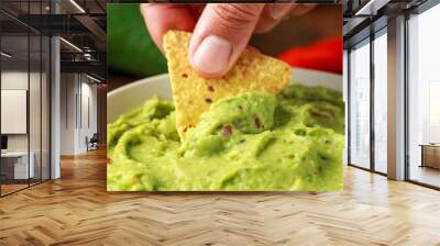 Man hand is picking some guacamole dip with nachos chip. Healthy Vegan, Vegetables food. Wall mural