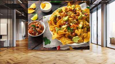 Mexican nachos tortilla chips with olives, jalapeno, guacamole, tomatoes salsa, cheese dipand beer. Wall mural