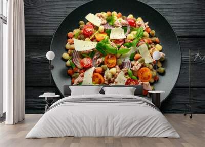 Mini potato gnocchi tricolour with tomato, spinach, Seasonal salad leaves and parmesan cheese on black plate Wall mural