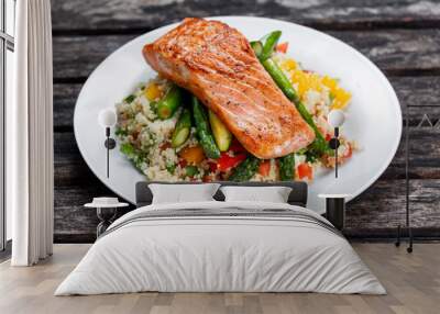 Pan fried salmon with tender asparagus and courgette served on couscous mixed with sweet tomato, yellow pepper salsa. Wall mural