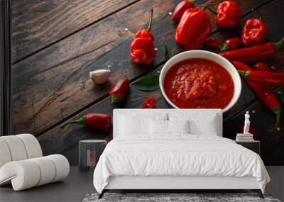 spicy hot sweet chili sauce with mix of chilli pepper, garlic and tomatoes on rustic wooden background Wall mural