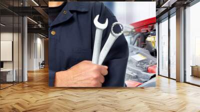 Hands of car mechanic with wrench in garage. Wall mural