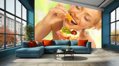 Pretty  woman eating the cake.. Wall mural