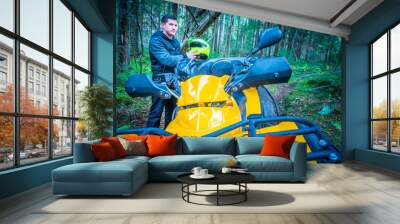 A man is preparing to go on the ATV. Riding an all-terrain vehicle. Riding a quad bike. Riding off-road on an ATV. Outdoor activity. Extreme. Rent a quad bike. Wall mural